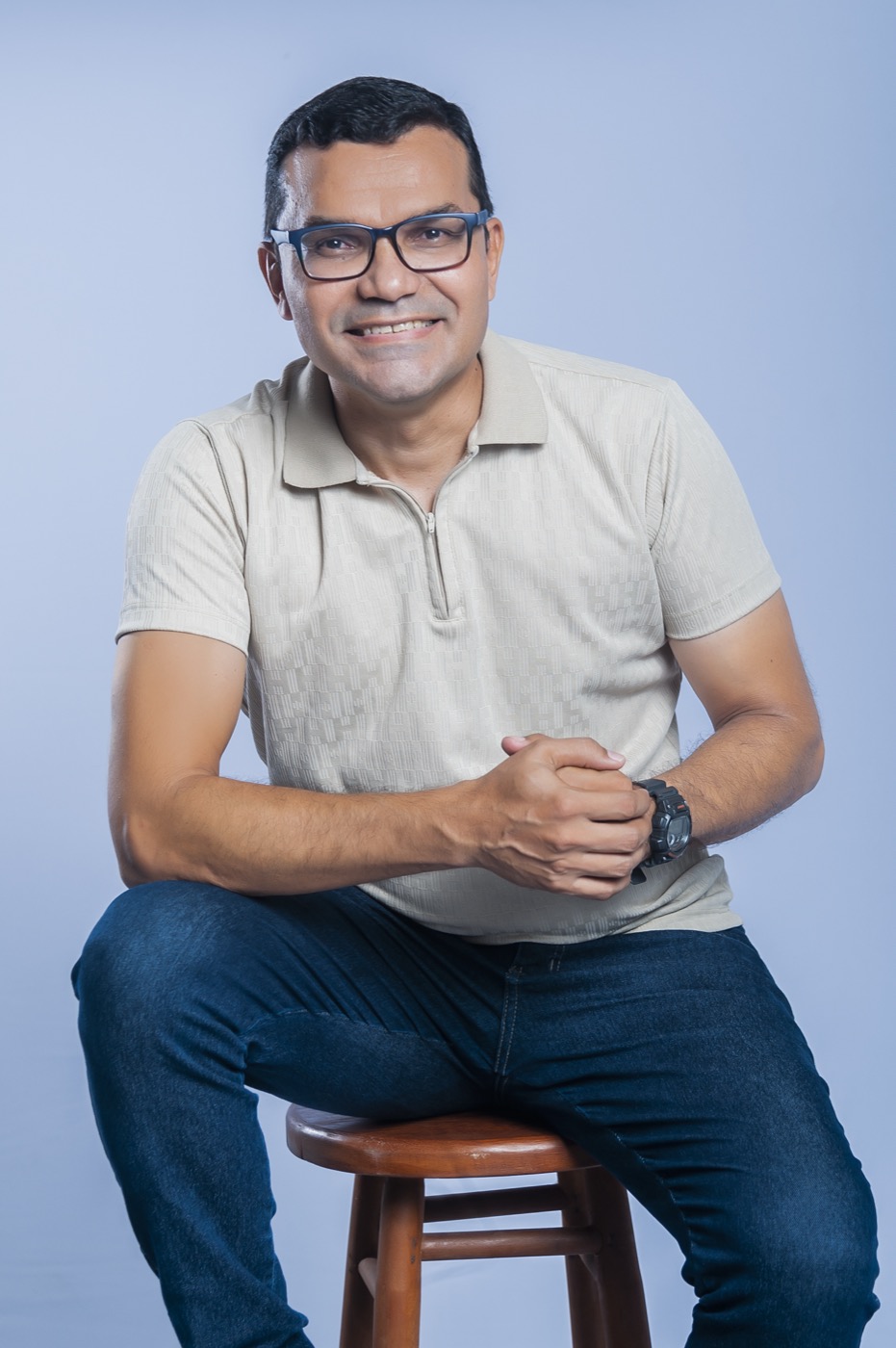 Davi Rocha sorrindo, sentado em estúdio